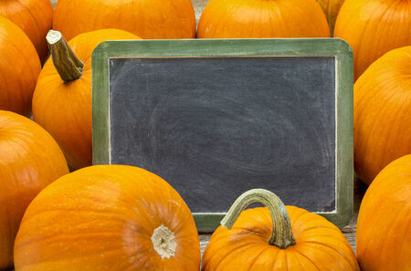 blank slate blackboard with white chalk smudges and pumpkin - Halloween or Thanksgiving themeの写真素材