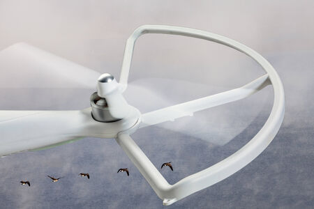 rotating propeller of a white quadcopter drone against foggy lake backgroundの写真素材