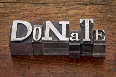 donate word in mixed vintage metal type printing blocks over grunge woodの写真素材