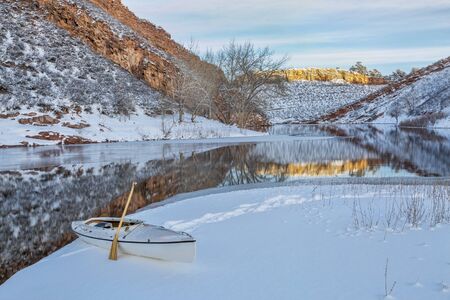 decked expedition canoe on icy shore  of Horsetooth Reservoir near Fort Collins in northern Colorado, winter sceneryの写真素材