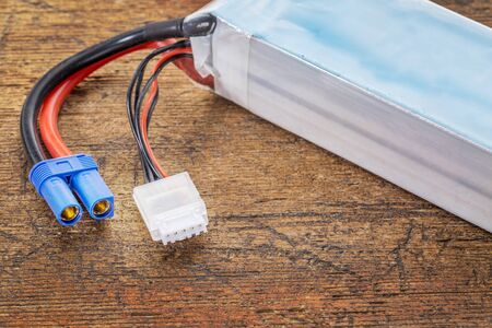 Lithium-ion polymer rechargeable battery (abbreviated as LiPo, LIP, Li-poly) with balancing and main power plugs. LiPo batteries are used in portable electronics, drones and radio controlled models.の写真素材