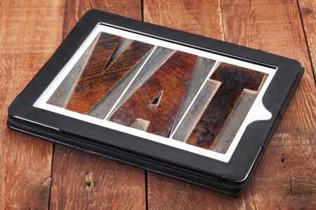 VAT (value added tax) - text in letterpress wood type printing blocks on a digital tabletの写真素材