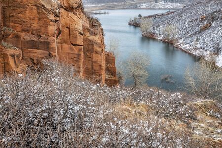 Old sandstone quarry on the shore of Horesetooth Reservoir near Fort Collins, Colorado, winter scenery with snow fallingの写真素材