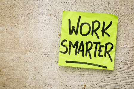 work smarter reminder on a green sticky note against rustic barn wood p productivity conceptの写真素材