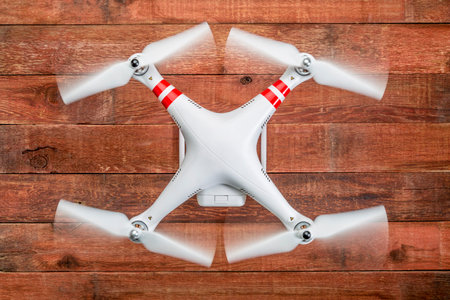 Fort Collins, CO, USA - March 17, 2015:  DJI Phantom 2 with spinning propellers, top view against rustic wooden wood tableのeditorial素材