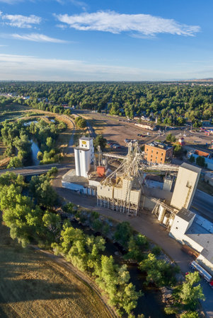 FORT COLLINS, CO, USA - September 4,  2015: Aerial view of industrial landmarks on the shore of Poudre River - historic Harmony Mill built in 1886 and Ranch-Way Feeds grain elevators the oldest continuously running business in town.のeditorial素材