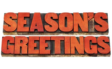 season greetings typography - isolated text in letterpress wood type stained by red inkの写真素材