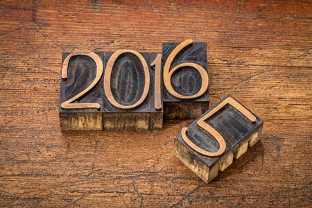 new year 2016 replacing the old year 2015 - letterpress wood type on a grunge wooden surface