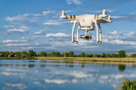 FORT COLLINS, CO, USA, SEPTEMBER 7 , 2015:  DJI  Phantom 3 quadcopter drone flying with a camera over a lake.のeditorial素材
