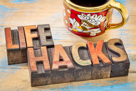 life hacks  - word abstract in vintage letterpress printing blocks stained by color inks with a cup...