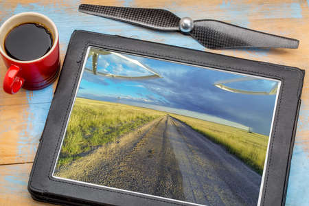 aerial landscape photography concept - reviewing aerial pictures of  a prairie in Colorado on a digital tablet with a drone propeller and coffee, screen picture copyright by the photographerの写真素材