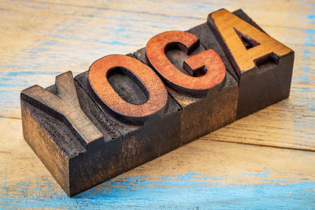 yoga word - text in vintage wood letterpress type blocks stained by color inksの写真素材