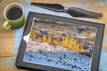 aerial photography concept - reviewing aerial picture on a digital tablet with a drone rotor...