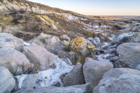 clay and sandstone erosion geological formations in Paint Mine Interpretive Park at Calhan near Colorado Springs, Colorado with a distant view of plains at sunriseの写真素材