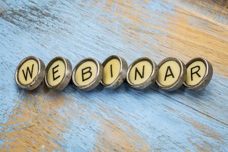 webinar word spelt in vintage typewriter keys against grunge woodの写真素材