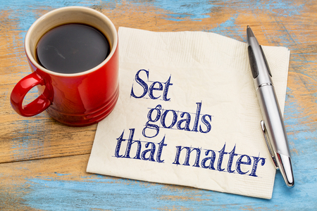 Set goals that matter  advice or reminder - handwriting on a napkin with cup of coffee against gray slate stone backgroundの写真素材