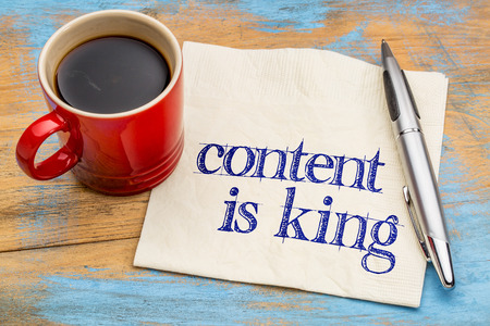 content is king - writing, blogging and publishing concept - handwriting on a napkin with a cup of coffeeの写真素材