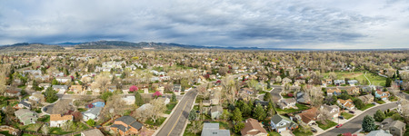 aerial panorama of Fort Collins in northern Colorado - residential buildings with Rocky Mountains foothills in background, early spring sceneryの写真素材
