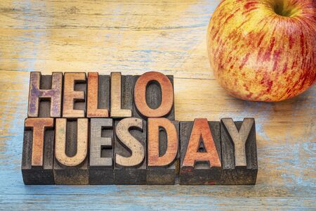 Hello Tuesday  - text in vintage letterpress wood type with an appleの写真素材