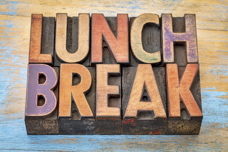 lunch break banner - text in vintage letterpress wood type printing blocks against grunge painted woodの写真素材