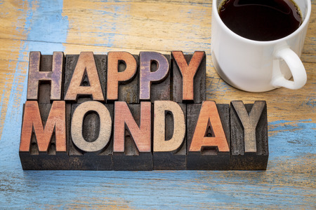 Happy Monday  word abstract in vintage letterpress wood type printing blocks stained by color inks with a cup of coffeeの写真素材