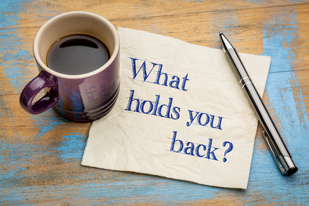 What holds you back? Handwriting on a napkin with a cup of espresso coffeeの写真素材