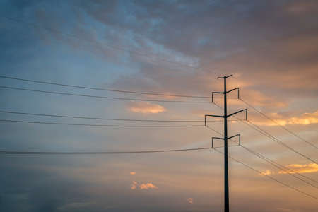 power line silhouette against sunset skyの写真素材