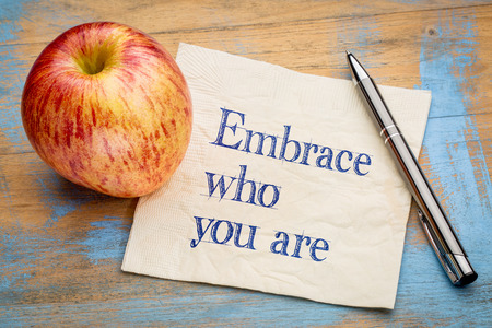 Embrace who you are - handwriting on a napkin with a fresh appleの写真素材