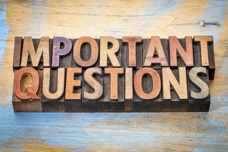 important questions - word abstract in vintage letterpress wood type against grunge painted woodの写真素材
