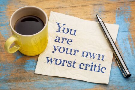 You are your own worst critic - handwriting on a napkin with a cup of espresso coffeeの写真素材