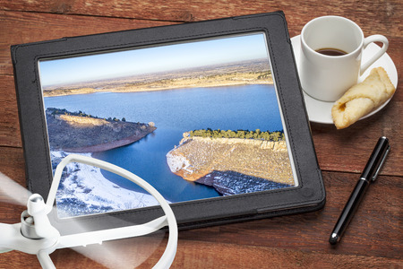 aerial photography concept - reviewing aerial pictures of the Horsetooth Reservoir on  a digital tablet with a drone rotor and coffee, screen picture copyright by the photographerの写真素材