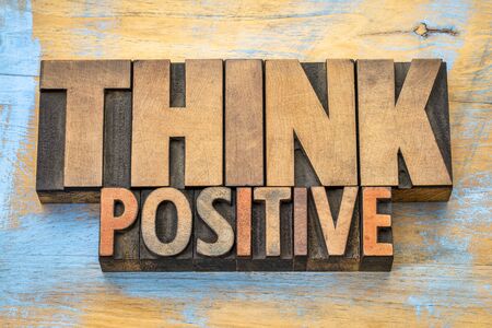 Think positive - word abstract in vintage letterpress wood type blocks against grunge wooden backgroundの写真素材