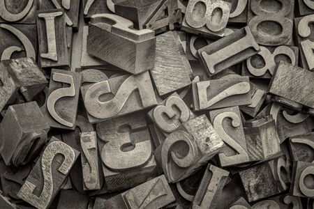 numbers abstract - background of random letterpress wood type printing blocks, top view, black and white platinum toned imageの写真素材