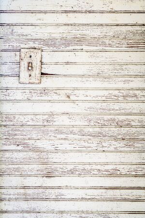 grunge white painted wood wall background with an electric switch