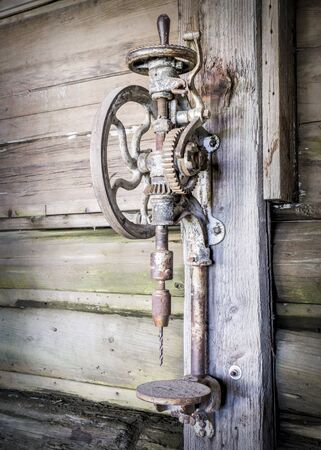 vintage rusty manual vertical drill in an old farm workshopの写真素材