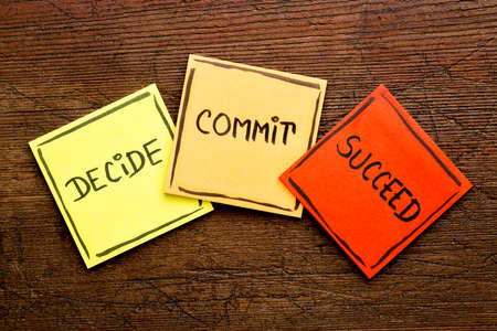 Decide, commit, succeed motivational word abstract on colorful sticky notes against rustic woodの写真素材