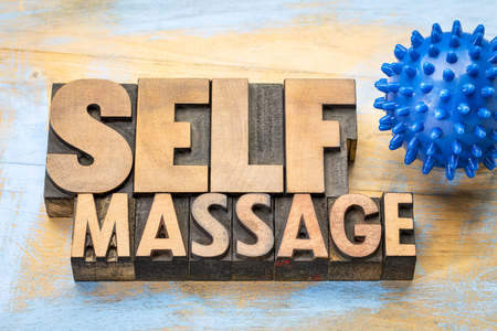 self massage word in letterpress wood type with a spiky rubber  ballの写真素材