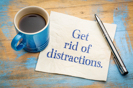 Get rid of distractions advice or reminder - handwriting on a napkin with a cup of espresso coffeeの写真素材