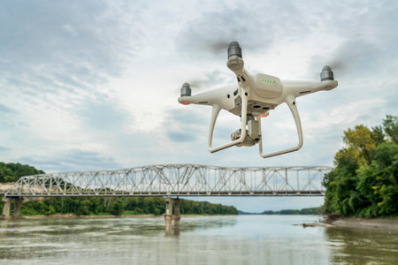 Overton, MO, USA - August 13, 2017S: drone flying with a camera over the MIssouri RIver with a highway bridge in background.のeditorial素材