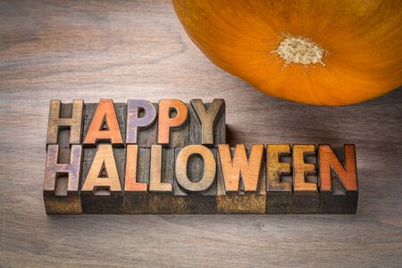 Happy Halloween greeting card - typography in vintage letterpress wood type with a pumpkinの写真素材