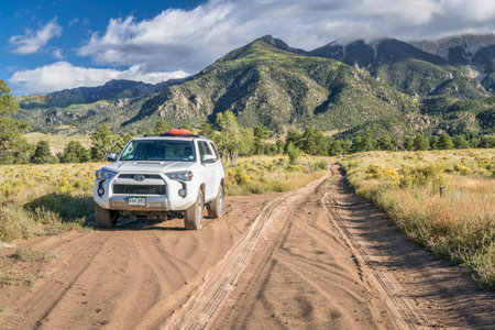 Great Sand Dunes National Park and Preserve - September 15, 2017: Toyota 4runner SUV (2016 Trail edition) with recovery sand ladders on roof driving on a sandy Medano Pass Road in late summer.のeditorial素材