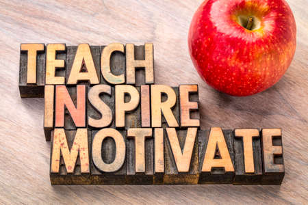 teach, inspire, motivate  concept in vintage letterpress wood type printing blocks with an appleの写真素材