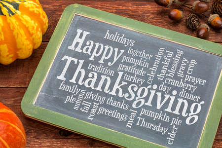 Happy Thanksgiving word cloud on a vintage slate blackboard with winter squashの写真素材