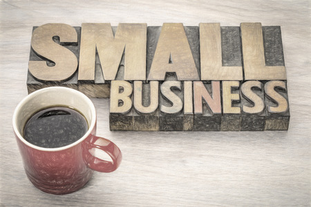small business word abstract in vintage letterpress wood type with a cup of coffee, charcho painitng digital effect