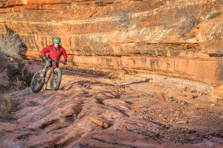 riding a fat mountain bike on a slickrock at the sandstone canyon bottom - Ruby Wash in Red Mountain Open Space north of Fort Collins, Coloradoの写真素材