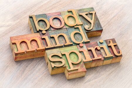 body, mind and spirit word abstract in letterpress wood type against grained woodの写真素材
