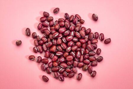 a small pile of Japanese adzuki (aduki, azuki) beans on pink backgroundの写真素材