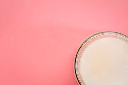 glass jar of coconut cooking oil on a pink background, top viewの写真素材