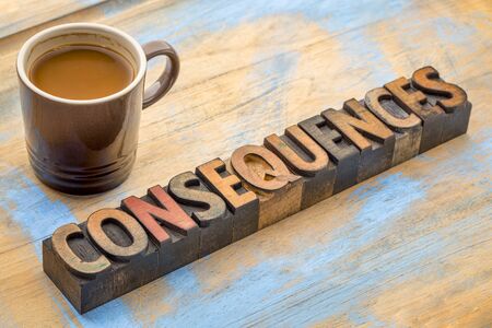 Consequences- word abstract in vintage letterpress wood type with a cup of coffee