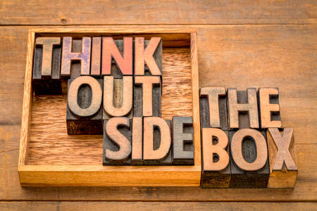 think outside the box concept- motivational phrase in vintage letterpress wood type against rustic  woodの写真素材